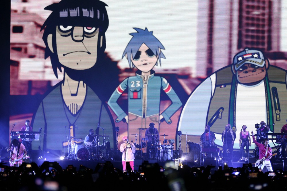 Damon Albarn on stage in front of animated band Gorillaz